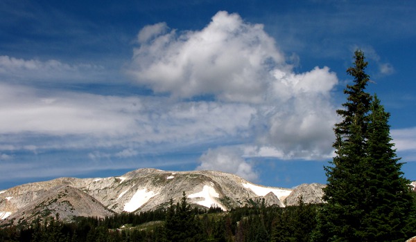 Snowy Mountains Crest Ridge with Cumulus Clouds